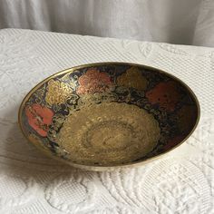 a decorative bowl sitting on top of a white table cloth