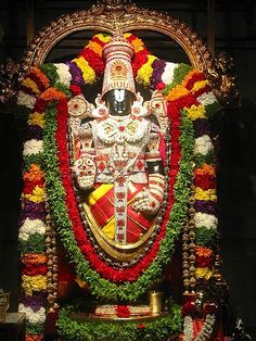 the statue is decorated with flowers and garlands