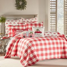 a red and white checkered comforter set on a bed in a room with pillows