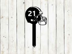 a football helmet with the number 21 on it is mounted to a wooden wall,