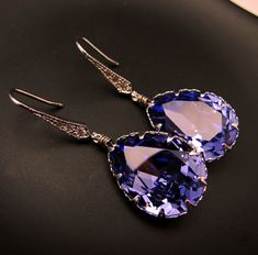 Foiled back tanzanite swarovski crystal teardrop framed with white gold plated metal bezel setting. White gold plated sterling silver earring hooks decorated with cubic zirconia. Size: 4.2cm x 1.4cm Earring Hooks, Silver Earring, Hook Earrings, Gold Plated Sterling Silver, Bezel Setting, Swarovski Crystal, Sterling Silver Earrings, San Jose, Swarovski Crystals