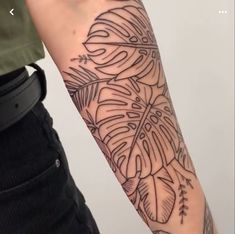 a person with a tattoo on their arm that has leaves and arrows all over it