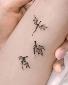 a woman's arm with three small leaves on it