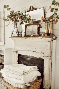 an old fireplace with white linens stacked on top