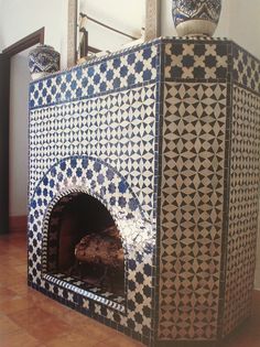 a blue and white tile oven with two vases on top