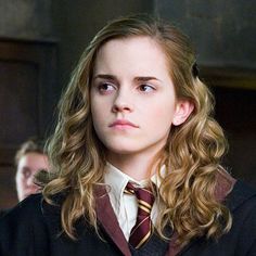 a young woman in a harry potter outfit looking at the camera with her hand on her hip