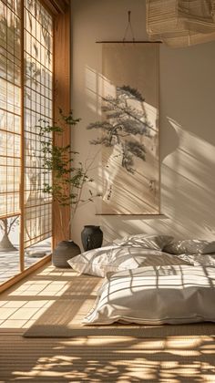 a bed sitting under a window next to a painting on the wall in a bedroom