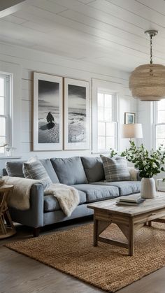 a living room with white walls and wood flooring, two pictures hang on the wall