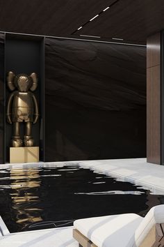 a gold bear statue sitting in the middle of a pool next to a wooden bench