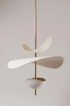 three white and gold objects hanging from a metal pole