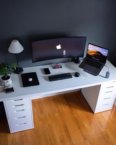 a white desk with two computers on it