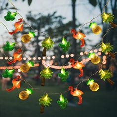 a string of lights that are hanging in the air with animals and pineapples on them