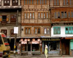 a woman is walking down the street in front of some buildings