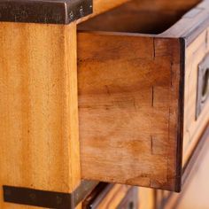 an old wooden cabinet with metal handles and drawers on it's sides, showing the bottom section