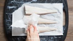 the person is preparing their food on the table with paper towels and napkins in front of them