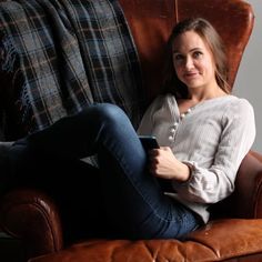 a woman sitting in a chair with her legs crossed