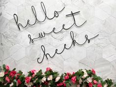 the words hello sweet cheeks written in cursive writing on a white marble wall