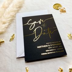 a black and gold save the date card on a table with confetti around it