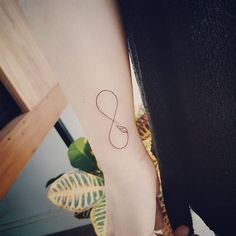 a woman's foot with a small tattoo on her left ankle and an infinite symbol