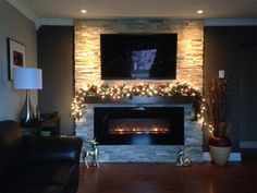 a living room with a fire place and christmas decorations on the fireplace mantels