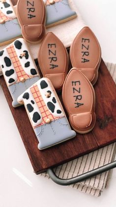 cookies decorated with farm animals and words on top of a wooden board next to a towel