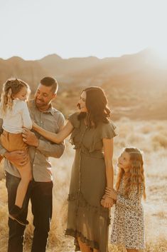 a family standing together in the desert at sunset