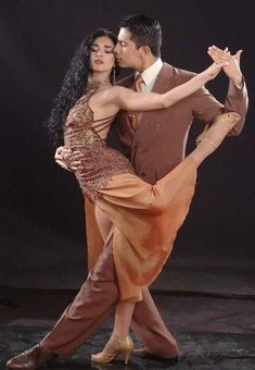 a man and woman are dancing together in an artistic dance pose with their arms around each other