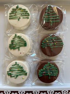 four decorated cookies in the shape of christmas trees