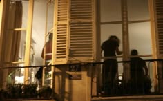 two people standing on a balcony at night