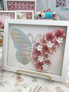 some paper flowers in a frame on a table