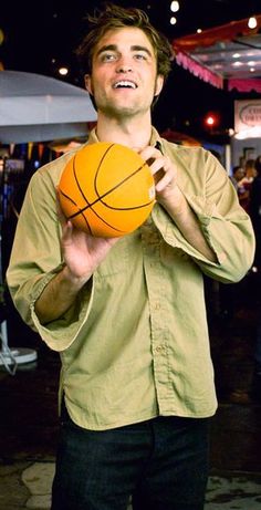 a man holding a basketball in his right hand and looking up at the sky with an excited look on his face