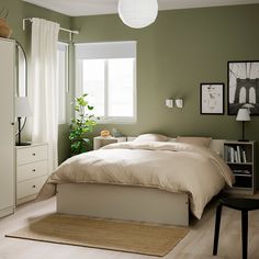 a bedroom with green walls and white furniture