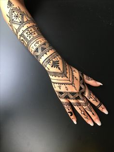 a woman's hand with hendix and tattoos on her arm, showing the design