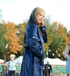 a woman in a blue coat talking on her cell phone