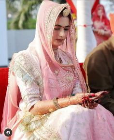 a woman in a pink bridal outfit sitting down