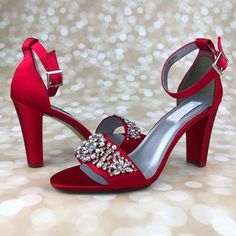 a pair of red high heeled shoes with jewel embellishments on them