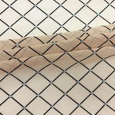 two baseball bats sitting on top of a white cloth covered field with black diamond netting