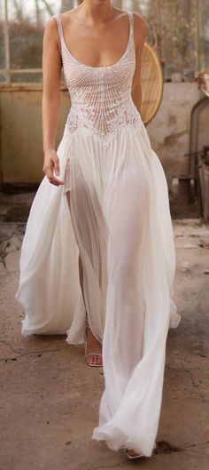 a woman in a white dress walking down the street