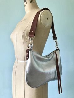 This versatile handbag is made in bright silver Italian leather.  Perfect for basic essentials, evenings out or adding a touch of glamour to autumnal days. Lined in a sturdy 100% cotton French ticking in blue/white stripe, this purse has a large inside slip pocket and a full length YKK zip closure for keeping everything safe.  It can come with either a tan brown (1.25 inch wide) leather crossbody strap (see images) or choose the 1.25 inch wide buckled crossbody strap from the variations below. Sweet Dumplings, Silver Purse, Basic Essentials, Silver Handbag, Brown Leather Handbags, Favorite Handbags, Bag Silver, Brown Purses, Evening Purse