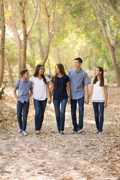 a family walking through the woods holding hands