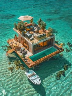 an aerial view of a floating house in the ocean with a boat and lounge chairs