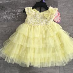 Sweet Yellow Tulle Dress Summer Princess Dress With Ruffles And Tiered Shape, Sweet Ruffled Dresses For Baptism, Sweet Fitted Dresses For First Birthday, Sleeveless Spring Dress For First Birthday, Sweet Ruffled Dress For First Birthday, Spring Ruffled Dress For First Birthday, Fitted Yellow Princess Dress For Spring, Summer Princess Tiered Dress, Summer Princess Ruffle Dress