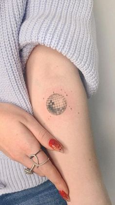 a woman's arm with a small globe tattoo on the left side of her right arm