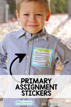 a young boy wearing a gray shirt with the words primary assignment stickers on it