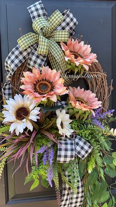 a wreath with sunflowers and greenery on the front door