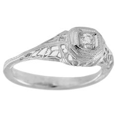 a white gold ring with an old - fashioned design and a round center stone in the center