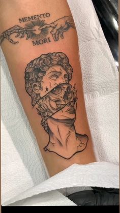 a man's arm with a tattoo on it that says mento mori