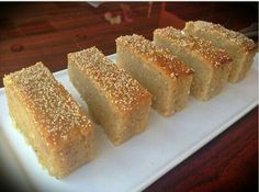 five pieces of cake on a white plate with some sugar sprinkled on top