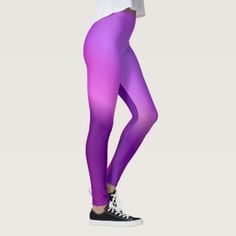 a woman in purple leggings is posing for the camera with her hands on her hips