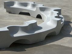 a white bench sitting on top of a cement ground